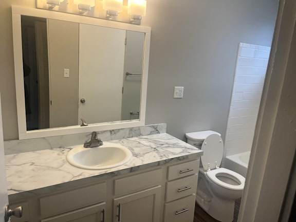 A bathroom with a marble countertop and a white toilet.