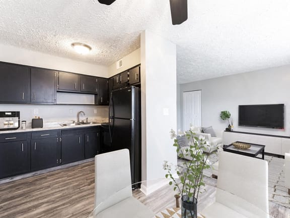 a kitchen and living room with a black refrigerator