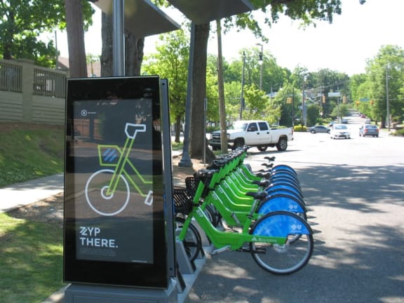 a row of green and blue bikes parked at a bench