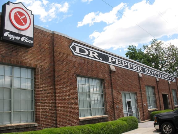 a building with a dr pepper bottling sign on the side of it