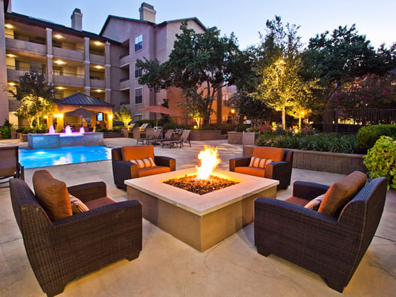 Cozy outdoor fire pit by the pool at apartments on Preston Road