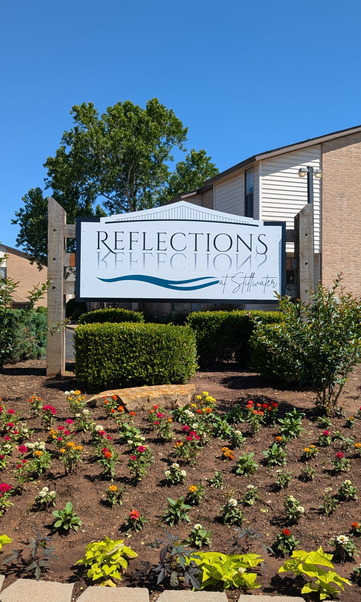 A sign for Reflections at Keefe is in front of a building.