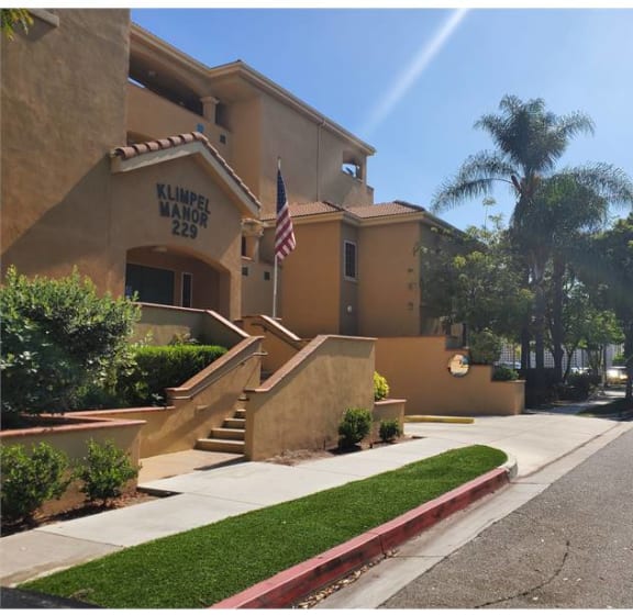 a building with stairs and an flag   and a street at KLIMPEL MANOR Apartments, Fullerton, CA