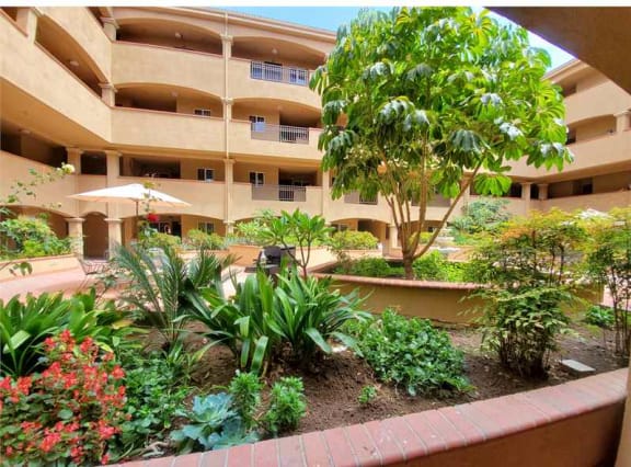 a garden in front of an apartment building at KLIMPEL MANOR Apartments, Fullerton, CA