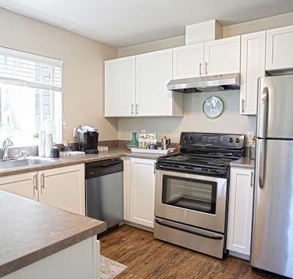 A kitchen with white cabinets and stainless steel appliances.
