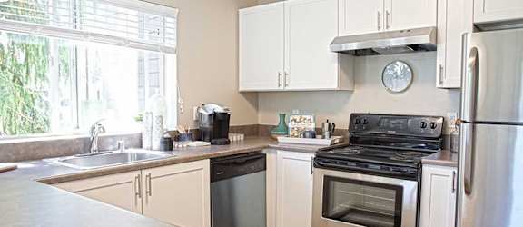 a kitchen with stainless steel appliances and white cabinets