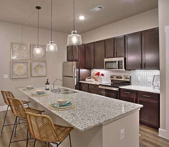 a kitchen with a marble counter top at Hunters Creek Apartments, Denton