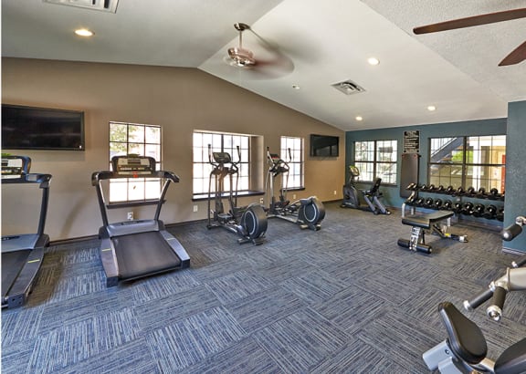 spacious fitness center with cardio machines and weights at villas at the heights apartments at Timberglen Apartments, Texas, 75287