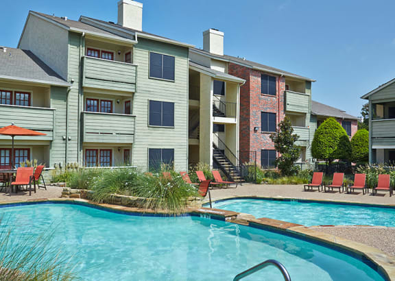 a swimming pool in front of an apartment building at Timberglen Apartments, Texas, 75287