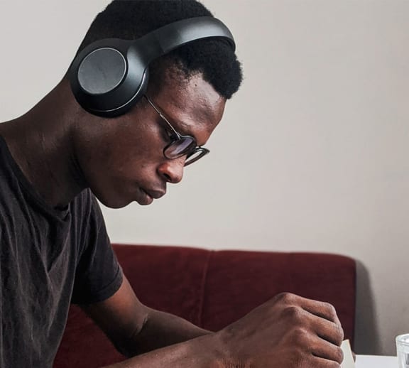 Male student studying with headphones on.