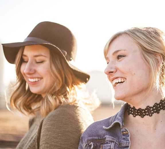 Two females outside smiling. 