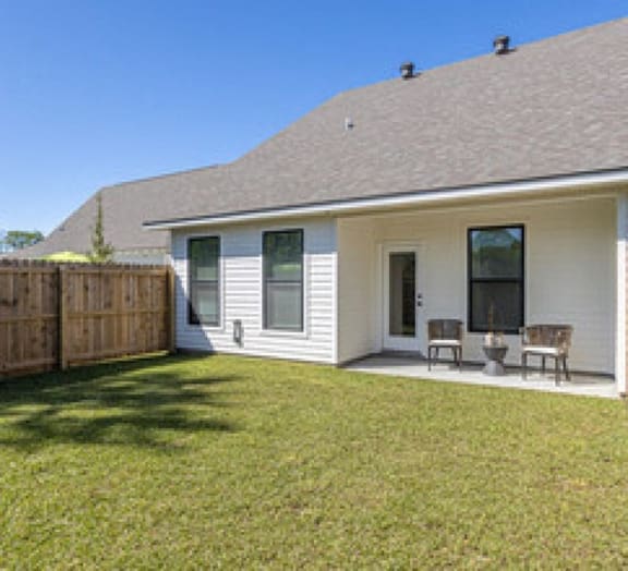 a white house with a yard and a wooden fence