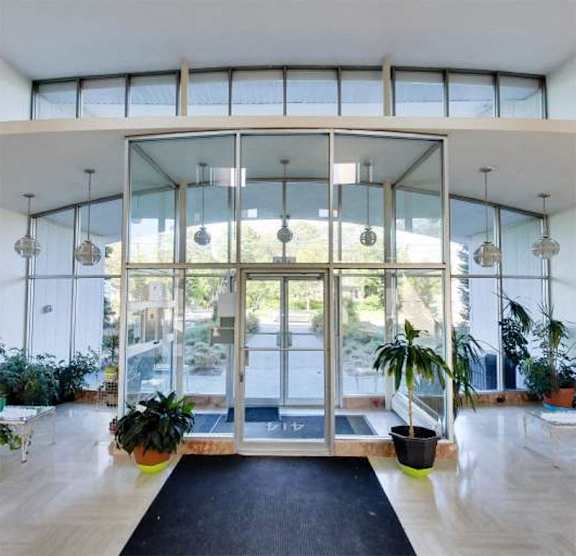 a large lobby with glass doors and potted plants