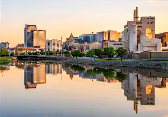 A city skyline is reflected in a body of water.