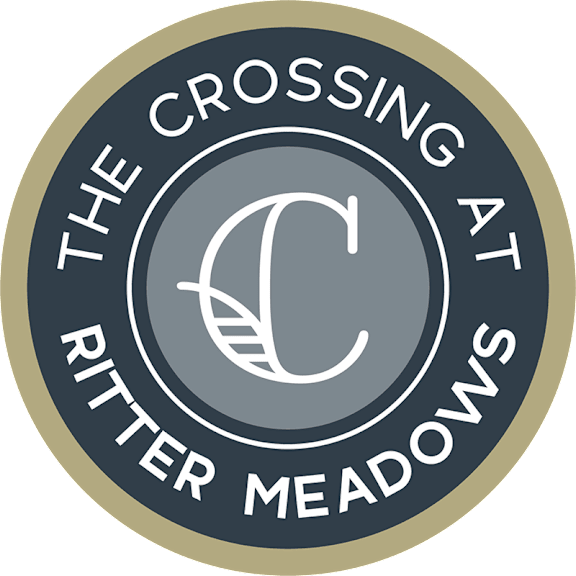 A logo with the text "The Crossing at Ritter Meadows" and a graphic of a leaf and a letter "C".