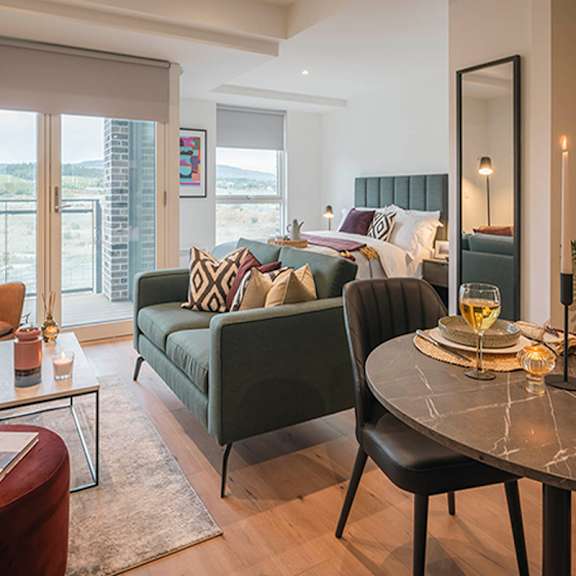 A bedroom with a green couch and a round table at Cherrywood Apartments, D18 VY3V, DUBLIN 18