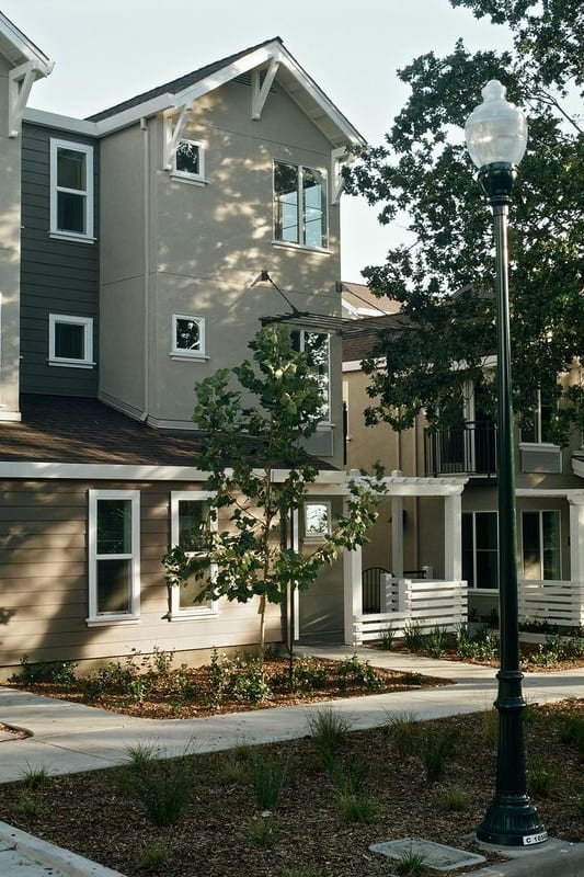 the courtyard between the two buildings is filled with benches and plants