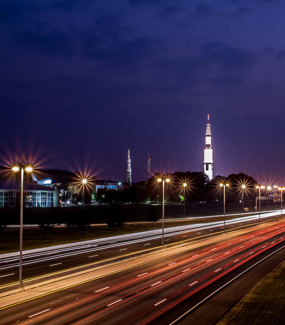 The US Space and Rocket Center at night with lights trails from cars traveling along I-565