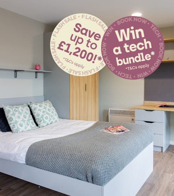 A bedroom with a bed, a desk, and a sign offering a discount on a Warwick University bus pass.