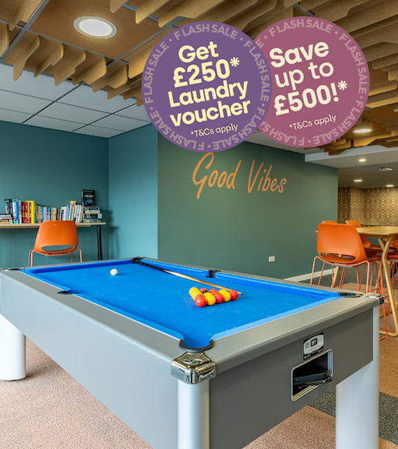 A pool table in a room with a sign that says "Save up to £1,000!"