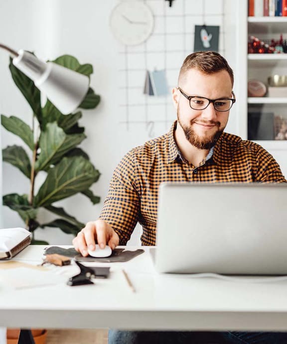a man sitting at a desk working on a laptop computer