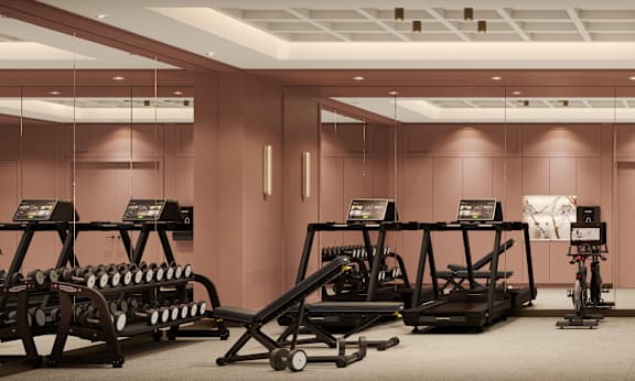 A gym with a variety of equipment including treadmills, weights, and exercise machines.