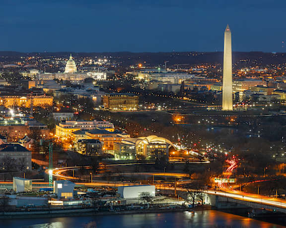 a cityscape at night with the washington monument in the background