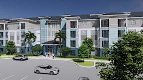 A modern apartment complex with a parking lot in front.