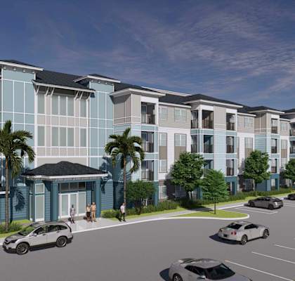 A modern apartment complex with a parking lot in front.