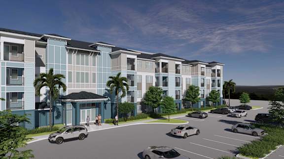 A modern apartment complex with a parking lot in front.