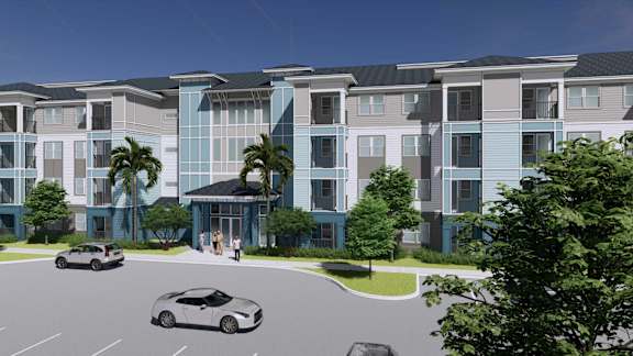 A modern apartment complex with a parking lot in front.