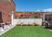 Thumbnail 10 of 42 - A patio with a table and chairs overlooking a red rocky hill. 605 Place Student Housing & Co-Living, St George, UT 84770