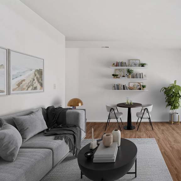 A modern living room with a grey sofa, a black coffee table, and a television on the right side.