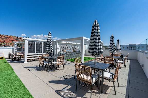 A patio with a table and chairs under black and white umbrellas. 605 Place Student Housing & Co-Living, St George, 84770