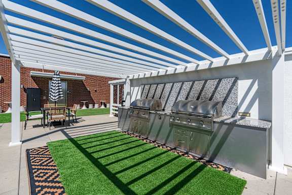 A patio with a white pergola and a grill. 605 Place Student Housing & Co-Living, St George