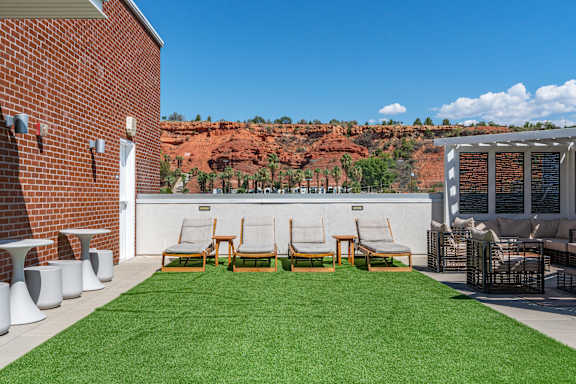 A patio with a table and chairs overlooking a red rocky hill. 605 Place Student Housing & Co-Living, St George, UT 84770