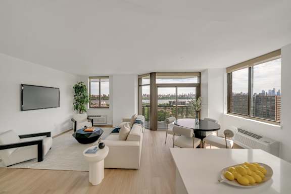 A modern living room with a flat screen TV mounted on the wall.