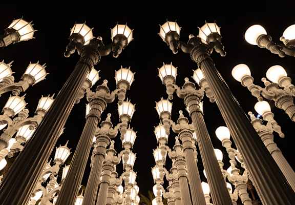 A series of white street lamps are lit up at night.