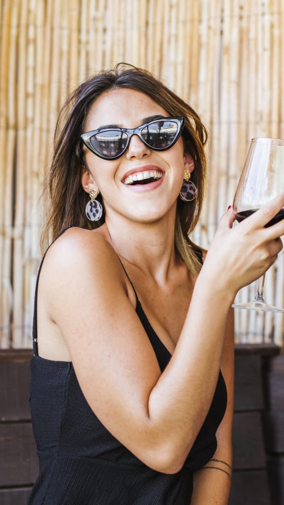 two women laughing and holding glasses of red wine at The Falls of Portofino, Florida, 34119