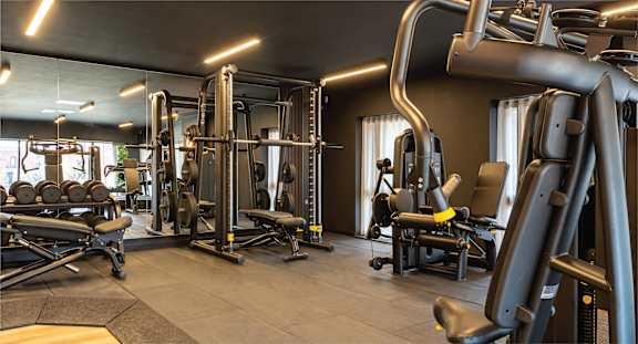 A gym with a variety of equipment including weights and machines.