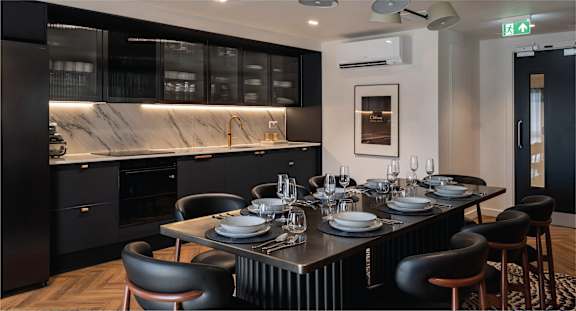 A modern kitchen with a dining table set for two.