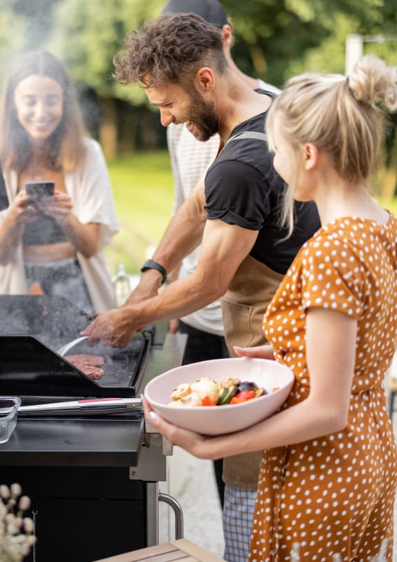 people grilling food in the backyard
