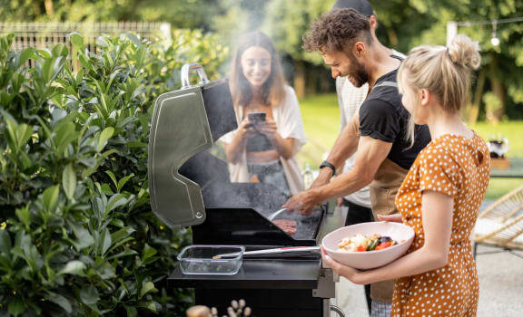 people grilling food in the backyard