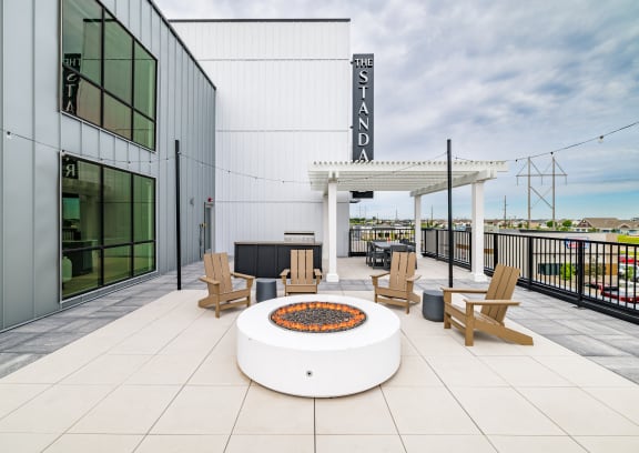 a patio with a fire pit and chairs and a building at The Standard on 32nd, North Dakota, 58078