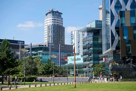 A modern building with a glass facade and the word "Theatres" written on it.