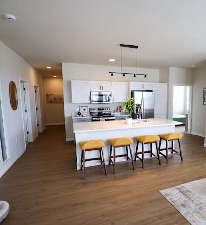 A kitchen with a white countertop and wooden floors.
