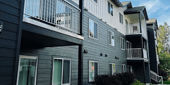 a man and woman with a little girl holding balloons and a bag at FALLS CREEK APARTMENTS, Coeur DAlene, Idaho