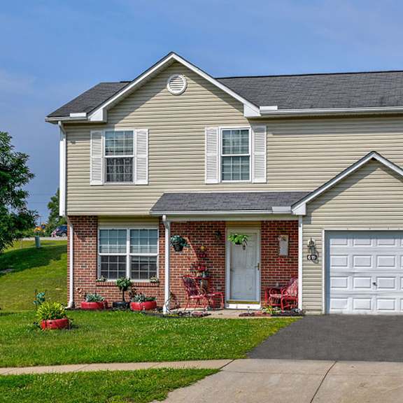A house with a grey roof and a white garage door.