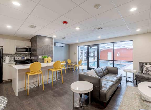 A modern living room with a kitchen area in the background.