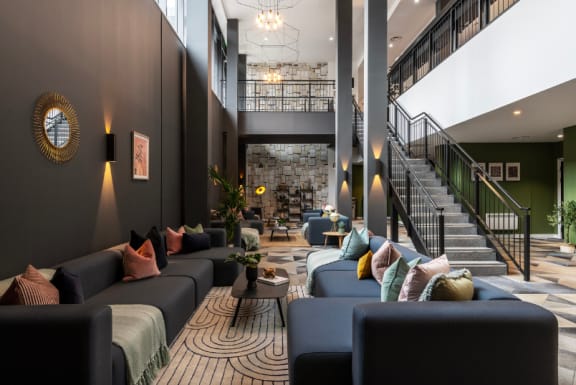 a lobby with couches tables and chairs and a staircase